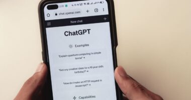 Close-up of hands holding a smartphone displaying the ChatGPT interface, representing AI search visibility