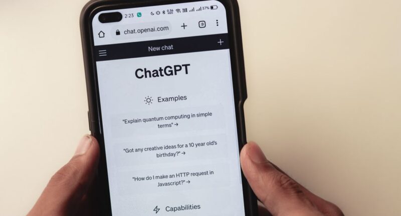 Close-up of hands holding a smartphone displaying the ChatGPT interface, representing AI search visibility