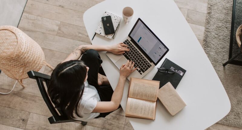 Freelancer typing on a laptop at a home desk, representing blog writing and publishing