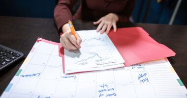 Person reviewing a financial document on an organized desk, representing vendor management for a small business
