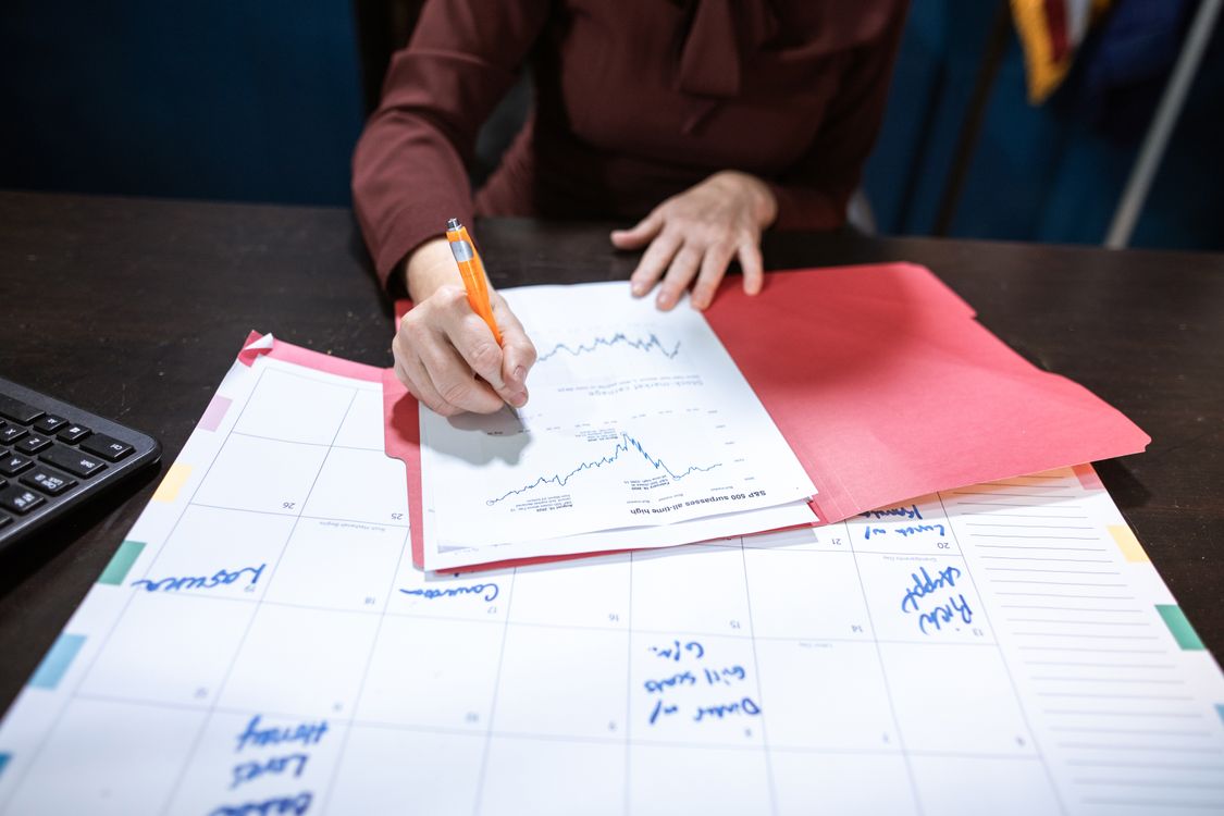 Person reviewing a financial document on an organized desk, representing vendor management for a small business