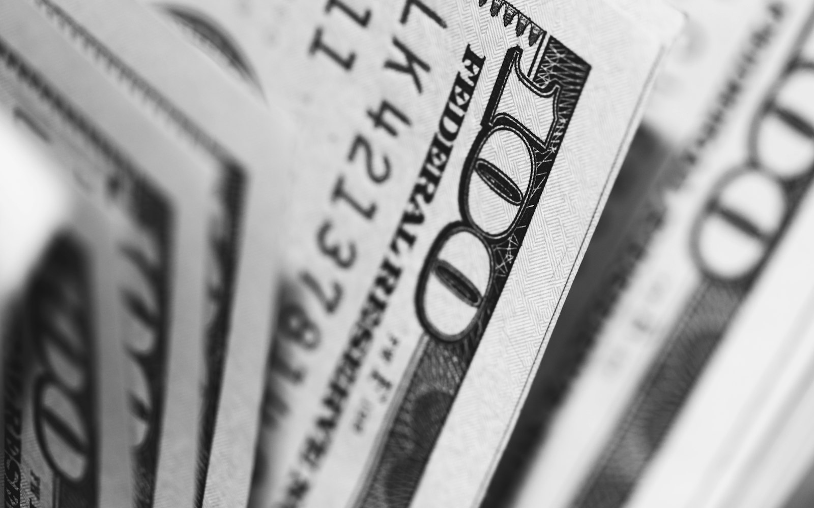 A close-up of stacked hundred dollar bills, representing where a bootstrapped first $10,000 actually goes