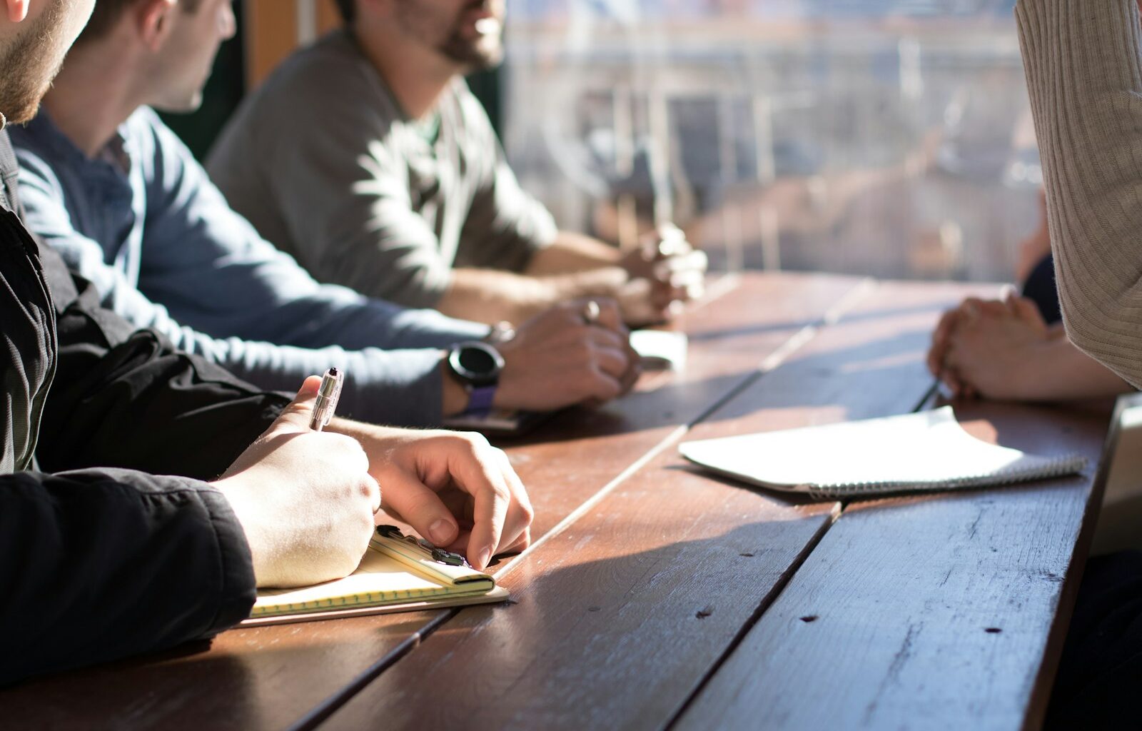 Team sitting together at a table working, representing delegation within a small team