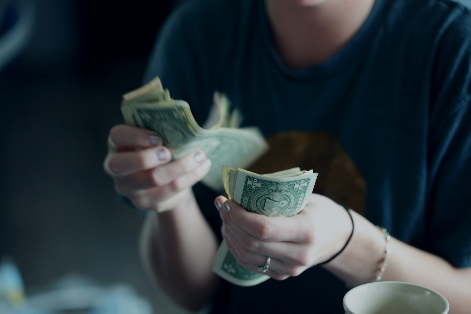 A person counting dollar banknotes, representing deciding how much to pay yourself in year one
