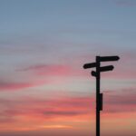 Silhouette of a road sign at a crossroads during golden hour, symbolizing a major career decision
