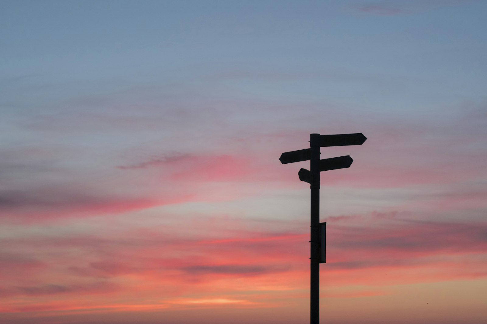 Silhouette of a road sign at a crossroads during golden hour, symbolizing a major career decision
