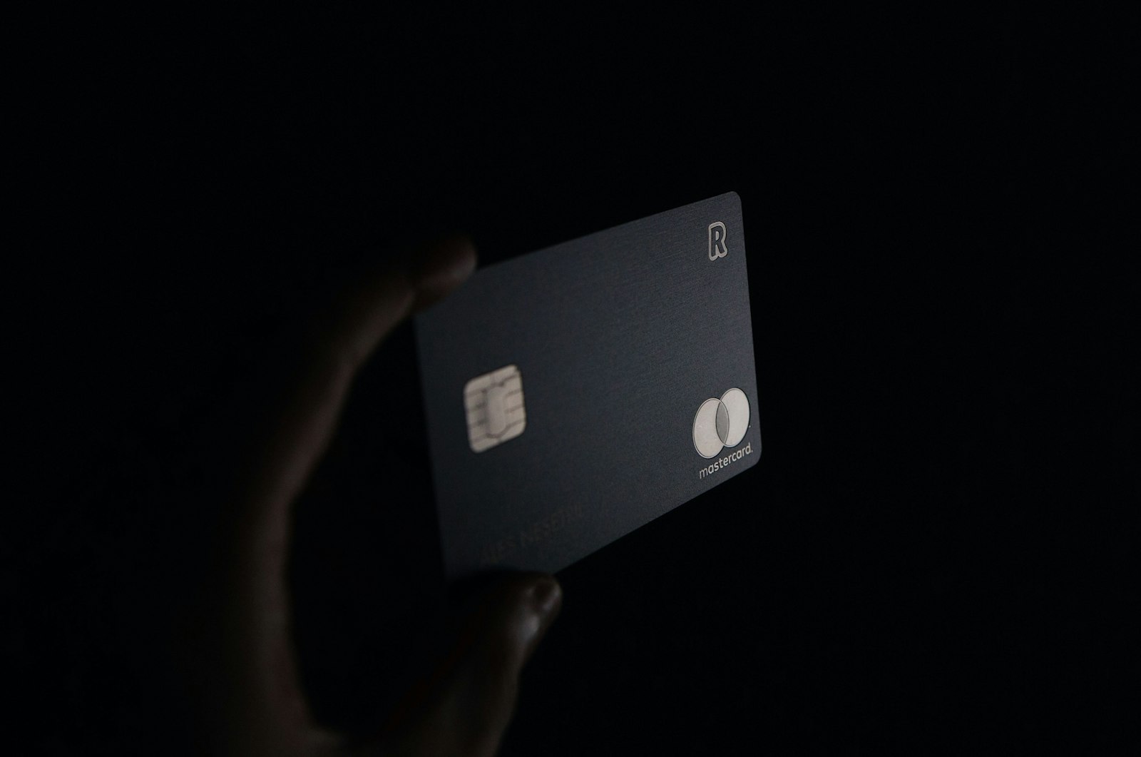 A person holding a black credit card, representing the business credit card mistake that costs founders