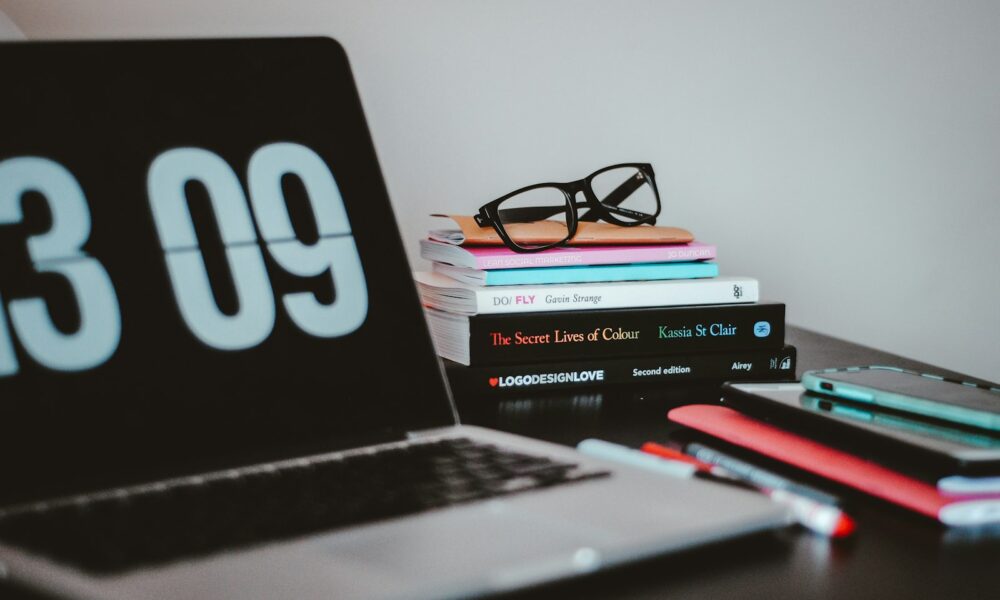 A laptop and books on a desk, representing crafting a standout resume and portfolio