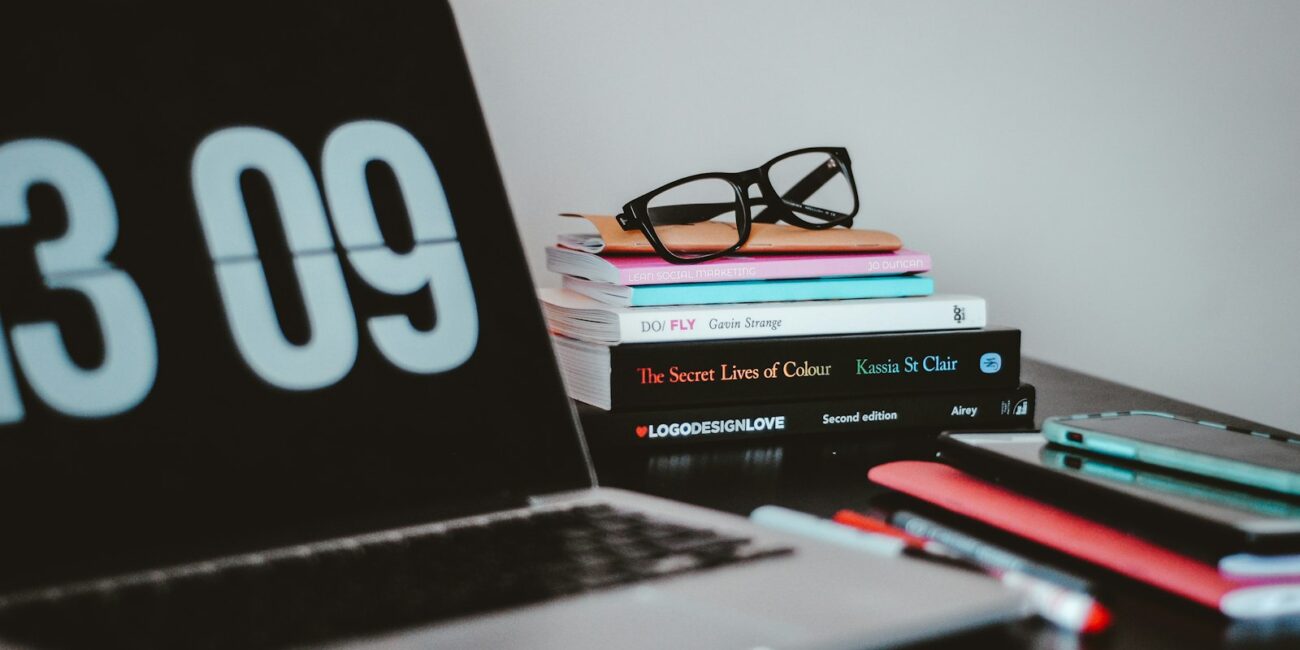 A laptop and books on a desk, representing crafting a standout resume and portfolio