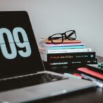 A laptop and books on a desk, representing crafting a standout resume and portfolio
