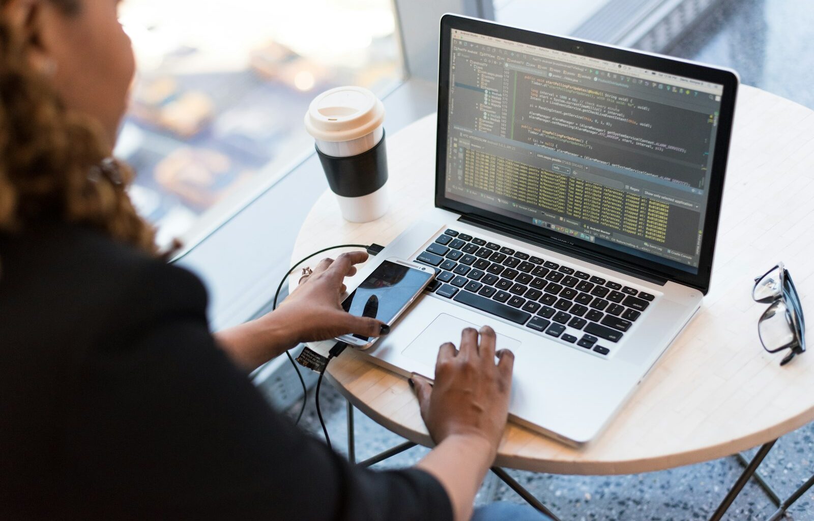 Woman working on a MacBook in an office setting, representing an interview conversation