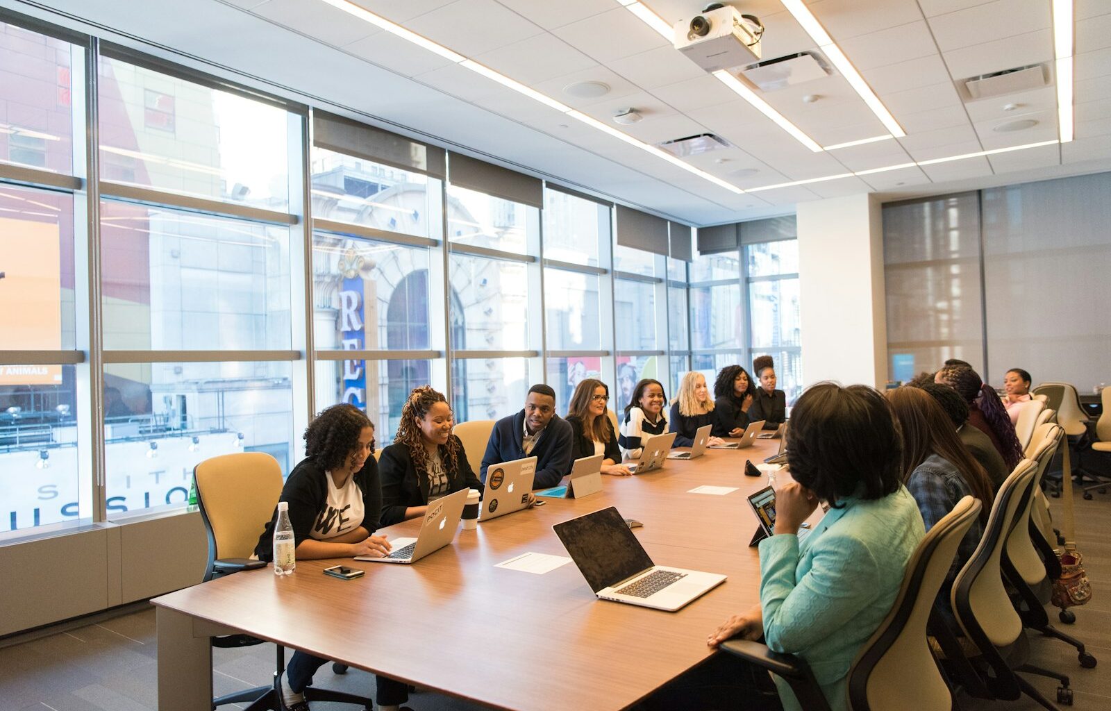 Small group of coworkers sitting together with laptops, representing a new hire's first days onboarding