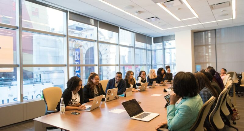 Small group of coworkers sitting together with laptops, representing a new hire's first days onboarding
