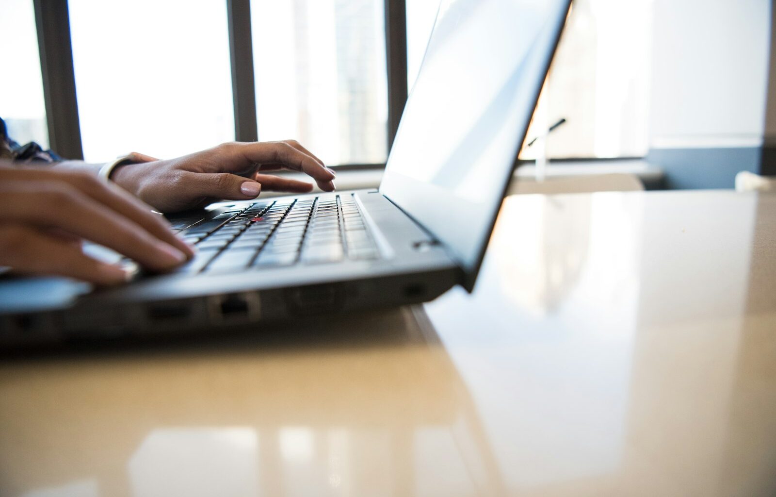 Person working on a laptop at a desk, representing a difficult employee conversation