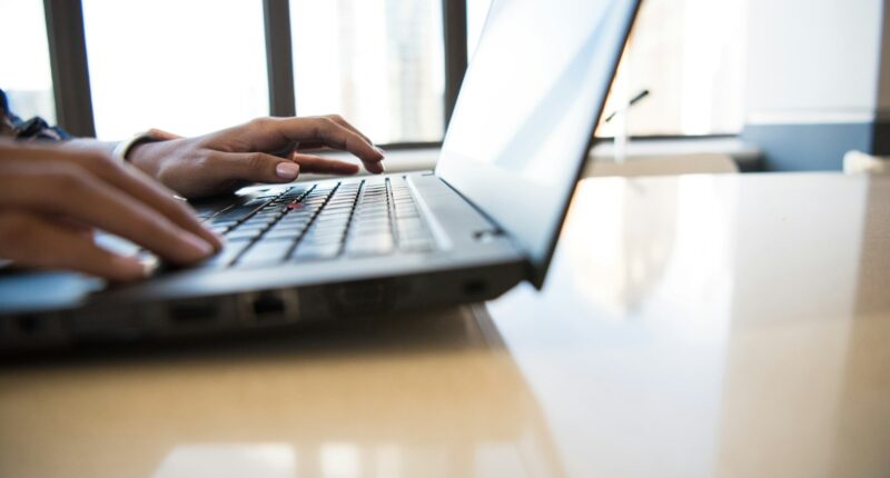Person working on a laptop at a desk, representing a difficult employee conversation
